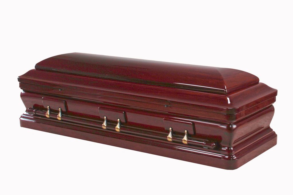 Glossy wooden coffin with brass handles.