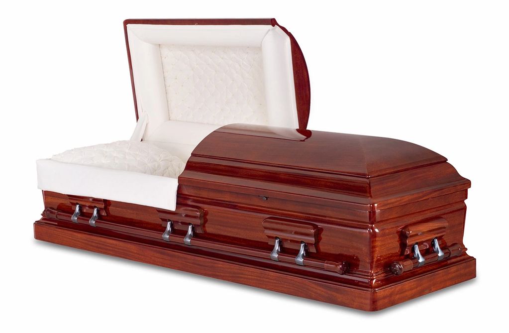 Polished wooden coffin with white interior and metallic handles.