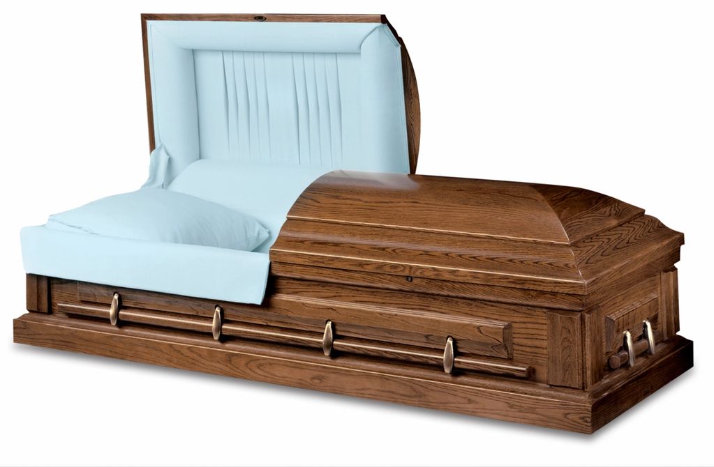 Wooden casket with white interior and pillow.