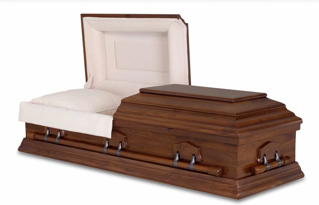 Wooden coffin with white interior lining.