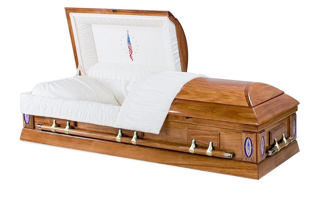 Wooden casket with white interior and American flag embroidery.