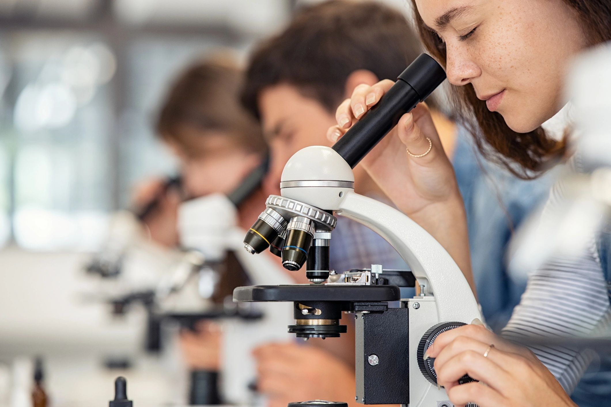 Student looking into microscope eyepiece