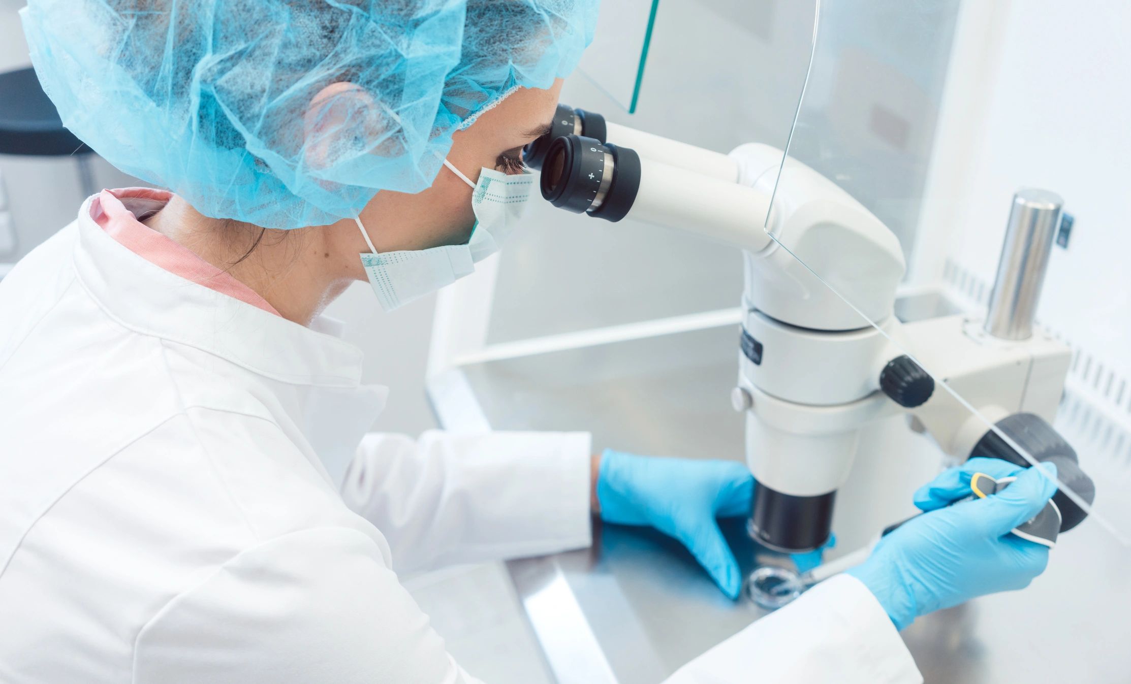 Lab technician working with stereo microscope