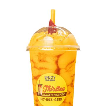 Bright mango boba drink with a strawberry garnish in a clear cup.