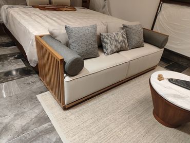 Modern sofa with wooden frame and gray cushions in a stylish room.