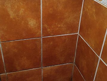Close-up of brown ceramic tiles arranged in a corner.