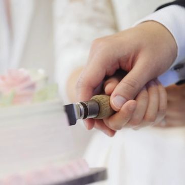 Bride and groom cutting white frosted wedding cake