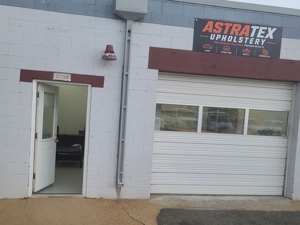 Exterior of AstraTex Upholstery workshop with open door and garage.