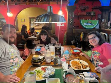 Three people enjoying a meal together at a restaurant table.