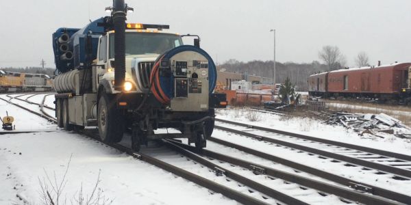 Special truck running on snowy railway tracks.