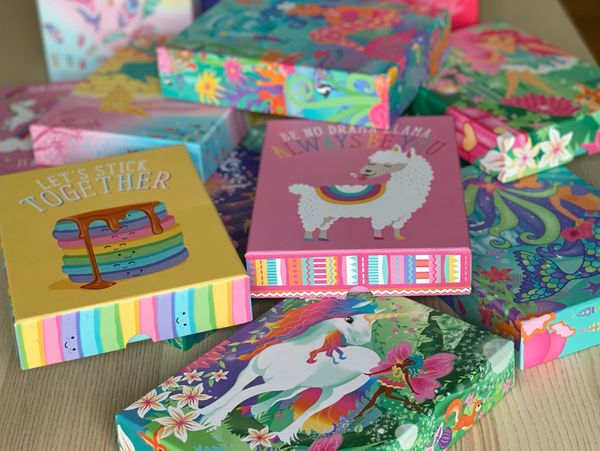 Colorful decorative boxes with whimsical designs and positive messages.