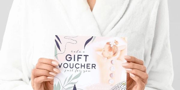 Person in white bathrobe holding a gift voucher indicating the sale of giftcards  Celtic Clan Health