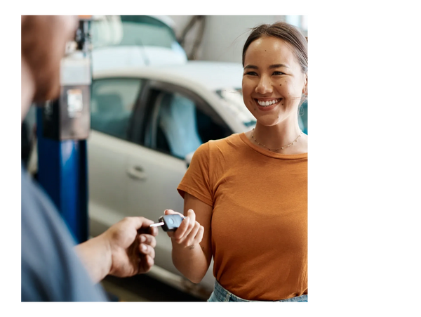 A female handing her keys to a automotive mechanic.