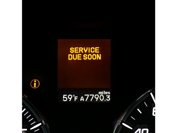 Automotive instrument cluster showing a service engine soon message.