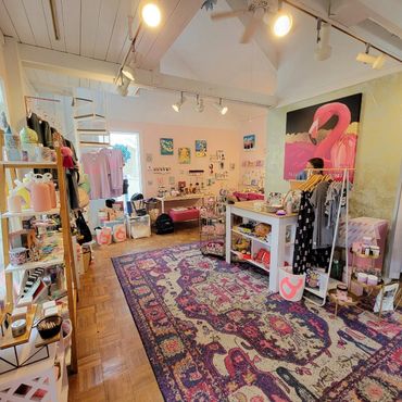 Bright boutique with colorful decor and a large flamingo painting.