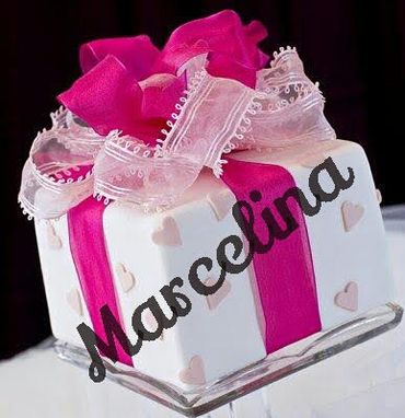 Gift box-shaped cake with pink ribbon and heart decorations.