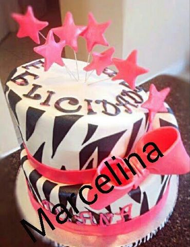 Two-tier zebra-striped cake with pink stars and ribbon.