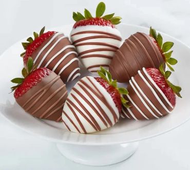 A plate of six chocolate-covered strawberries with decorative drizzles.
