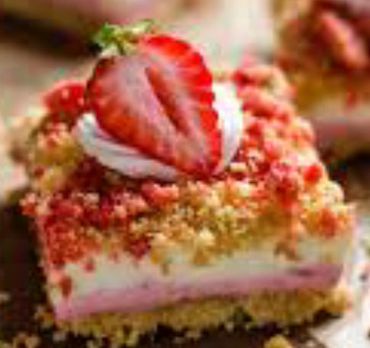 Strawberry crumb cake with whipped cream and fresh strawberry slice.