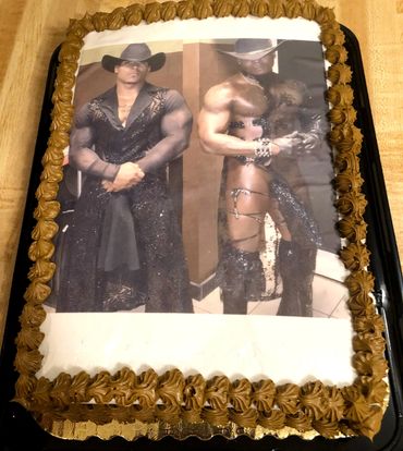 A rectangular cake with an image of a muscular man in cowboy attire.
