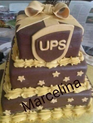 Three-tier UPS-themed cake with brown and yellow icing, decorated with stars and a bow.