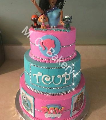 A colorful three-tiered cake with Paw Patrol characters and decorations.
