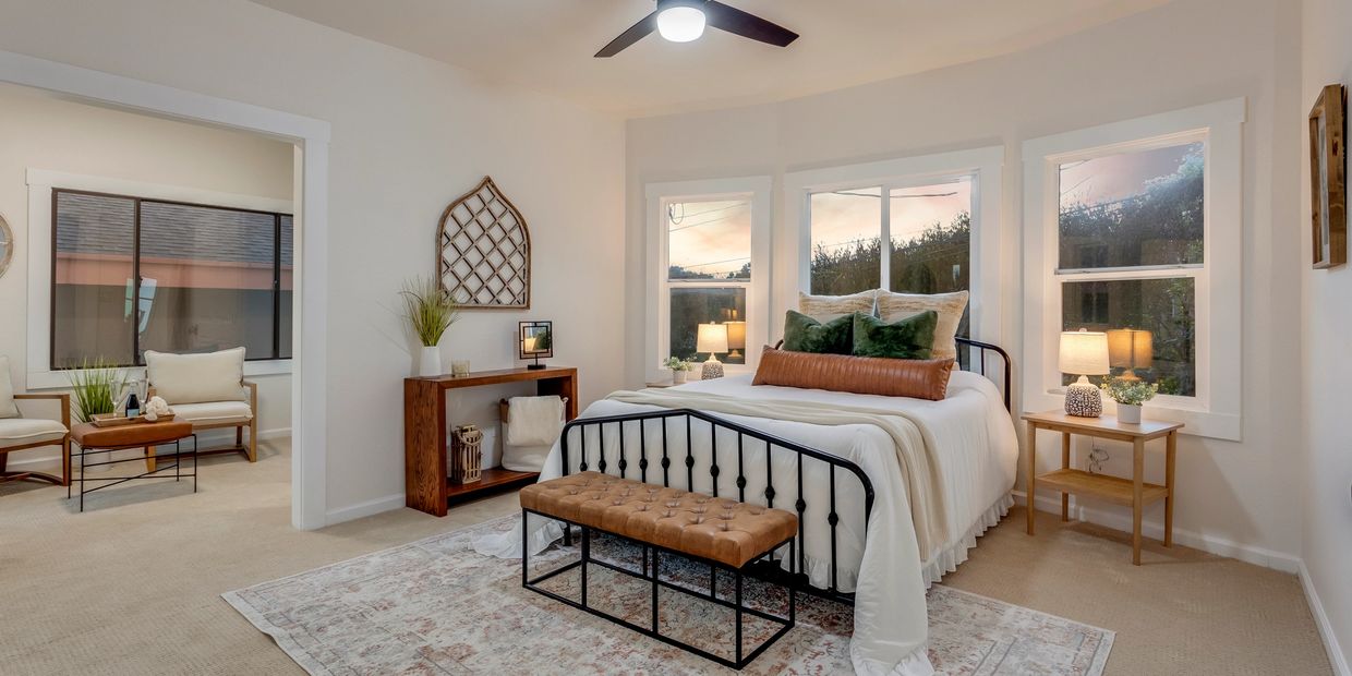 Cozy bedroom with a black metal bed frame and warm-toned decor.