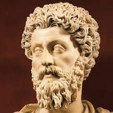 Close-up of a detailed ancient marble bust of a bearded man with curly hair.