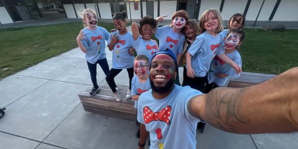 Group selfie with painted faces and matching shirts.