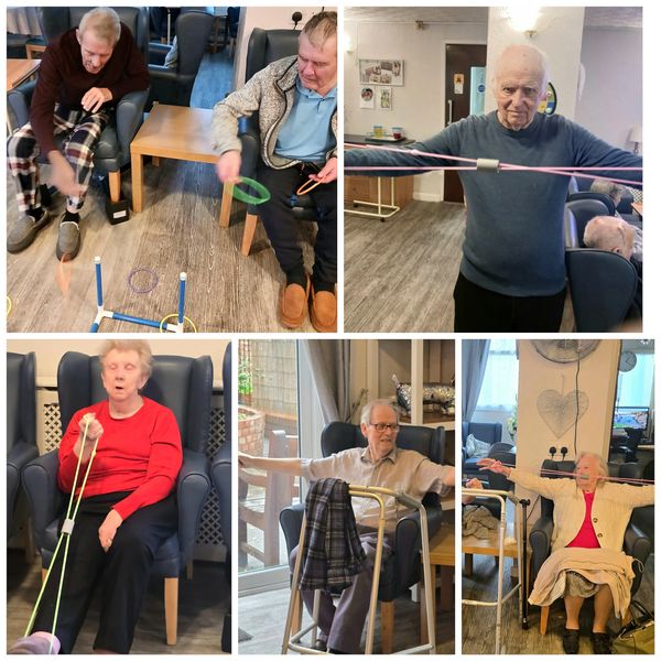 Elderly people engaging in seated exercises and games in a community room.