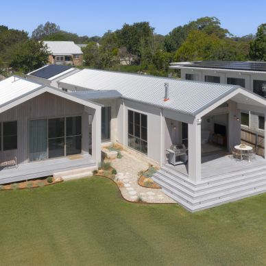 Modern single-story house with metal roof and patio.