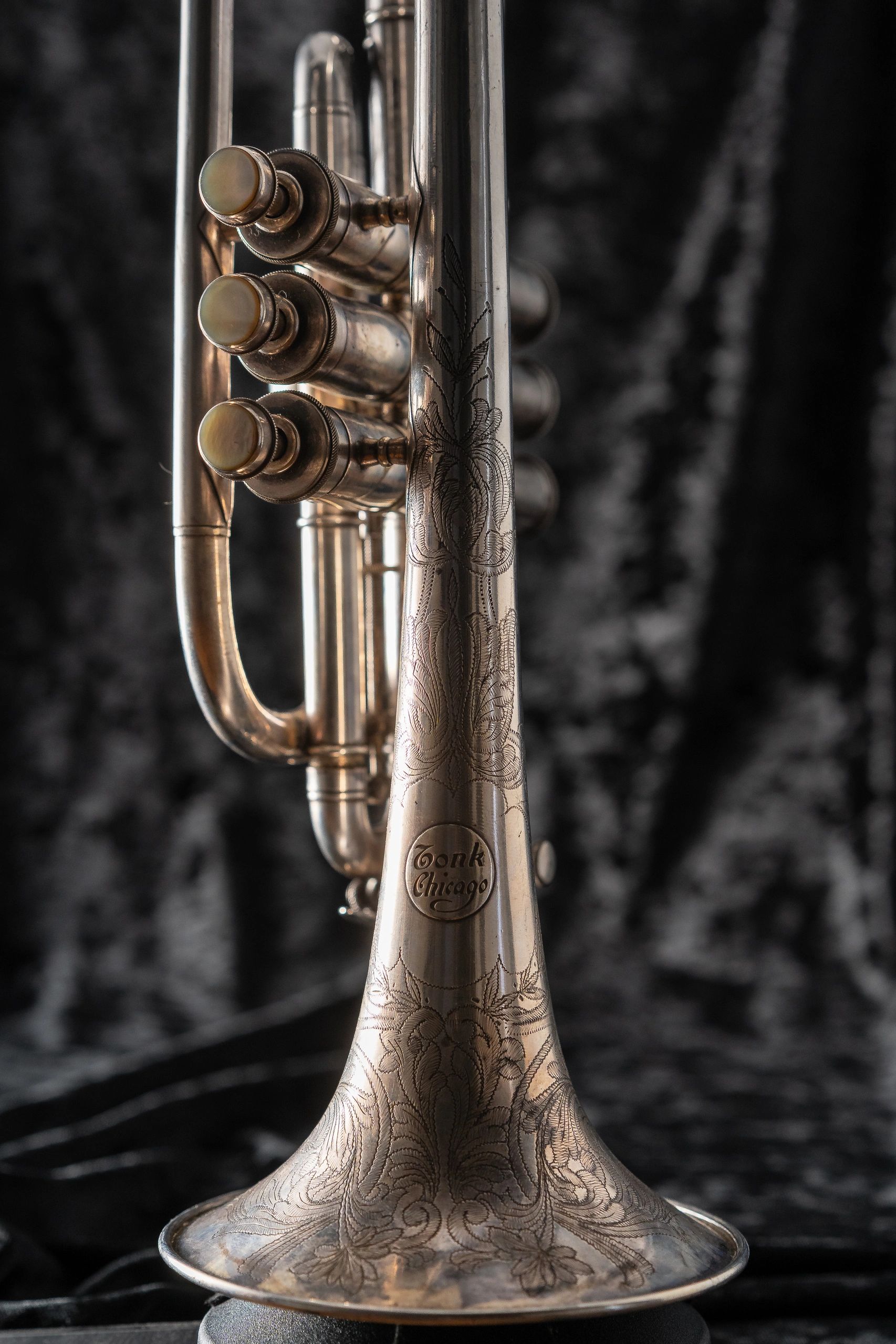 Close-up of an intricately engraved vintage Tonk Chicago trumpet.