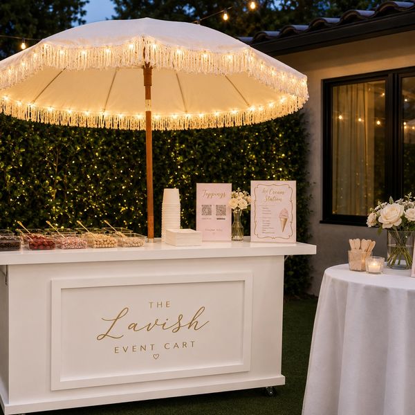 Elegant outdoor ice cream cart setup with lights and decorations.