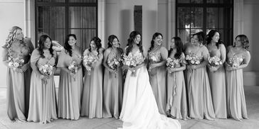 Bride with bridesmaids in blue dresses holding bouquets.