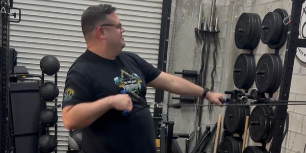 Man using resistance cables in a gym.