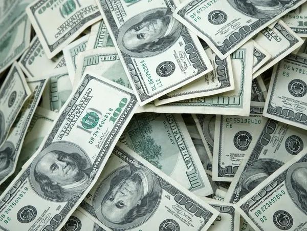A pile of US 100-dollar bills scattered.