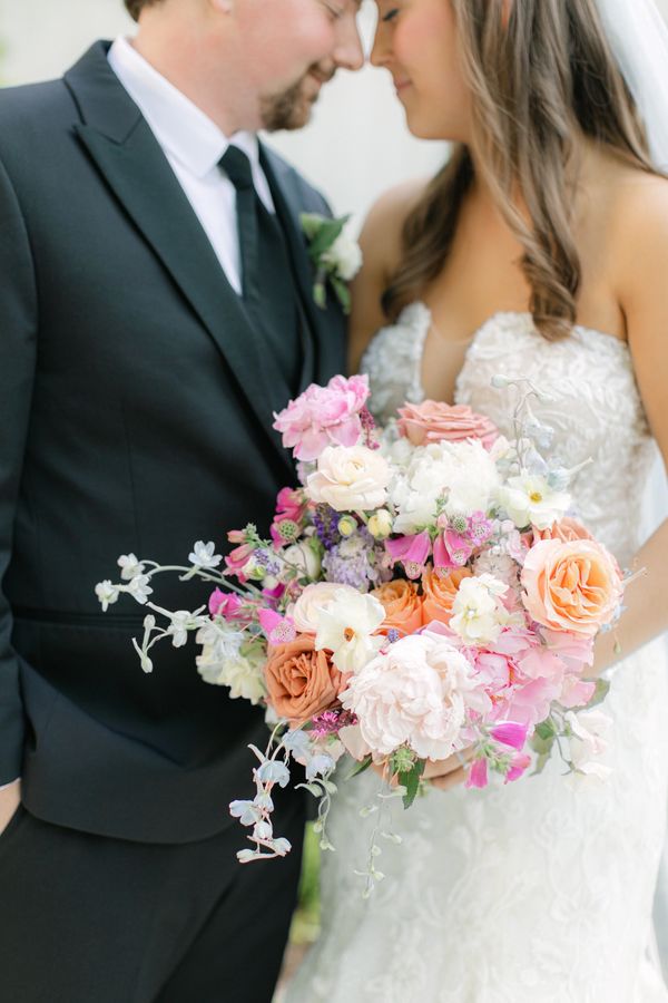 bride and groom portrait, pink and pastel wedding bouquet. strapless wedding dress