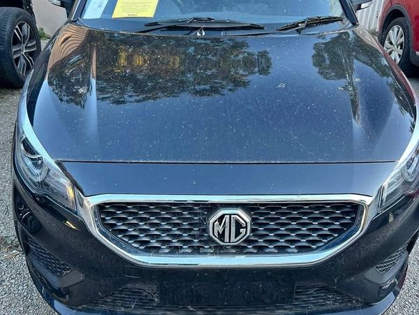 Front view of a black MG car with a shiny grille and logo.