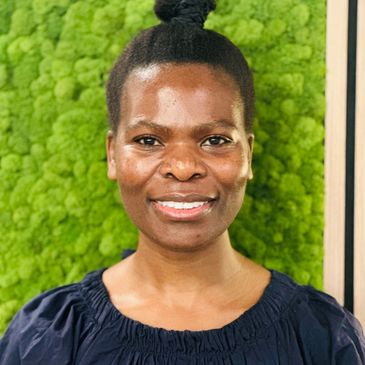 Smiling woman with natural hair against a green textured background.