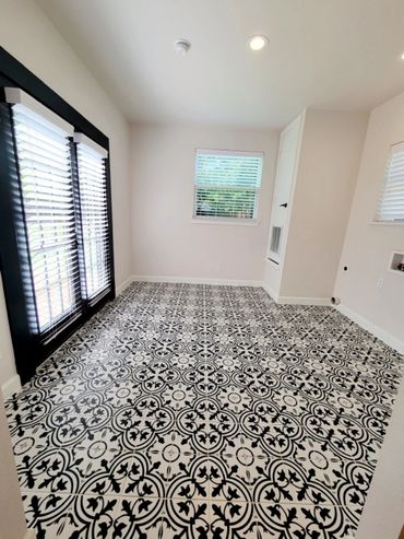 A vacant room with blinds and black and white tiles