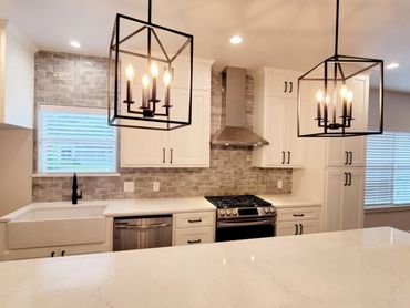 Black ceiling lights above the kitchen countertop
