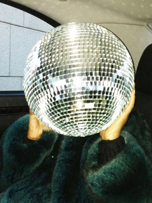 Person holding a disco ball in front of their face.