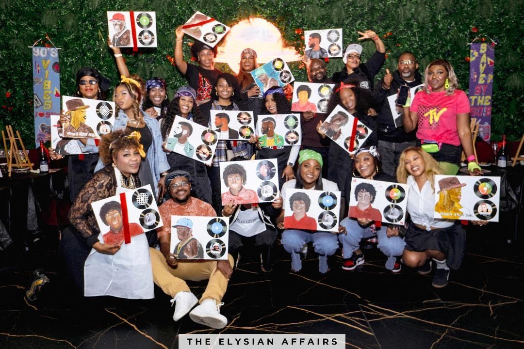 Group of people proudly holding painted portraits of iconic music figures.