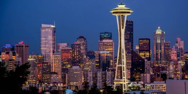 Seattle skyline at dusk featuring the Space Needle and illuminated buildings.