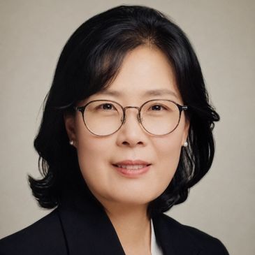 Professional portrait of a woman with glasses and a blazer.