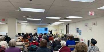 Dr Gupta giving a presentation to a group of seniors in a senior living setting