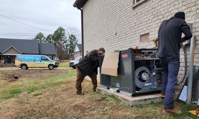 Endless Comfort HVAC technicians installing a new packaged HVAC unit with the van in the background.