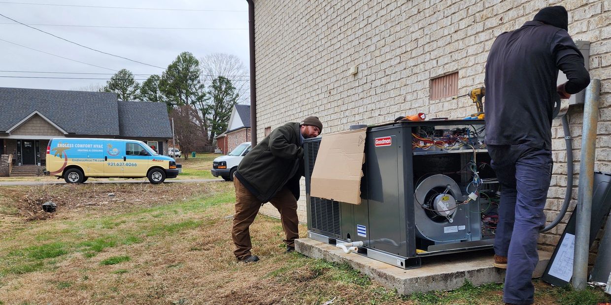 Two HVAC installers working on a new unit for a home.