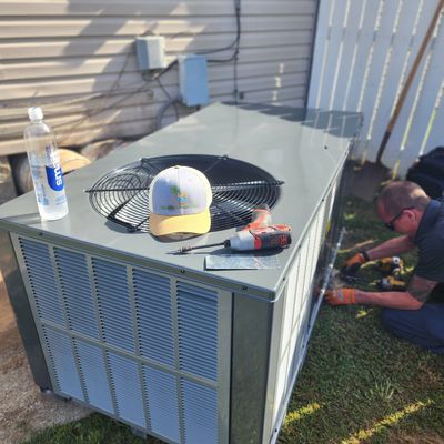 Endless Comfort HVAC technician installing a new outdoor A/C unit beside a home in Middle Tennessee.