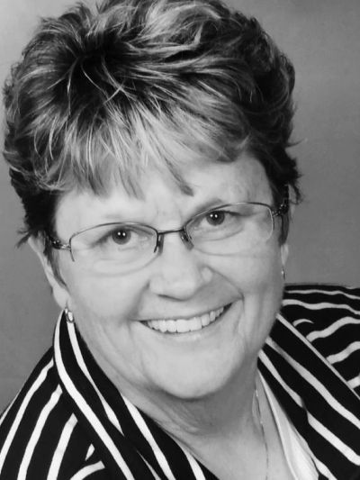Smiling woman wearing glasses and a striped shirt.